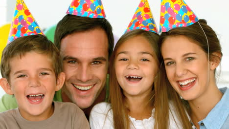 Portrait-of-smiling-family-with-party-hats