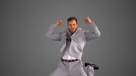 Succesful-businessman-jumping-on-grey-background