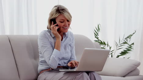 Mujer-Hablando-Por-Teléfono-Usando-Una-Computadora-Portátil