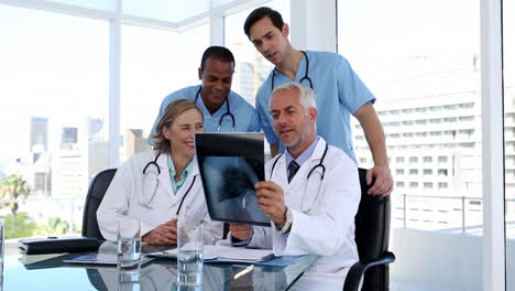 Grupo-De-Médicos-Examinando-Juntos-Una-Radiografía