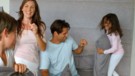 Smiling-family-having-a-pillow-fight