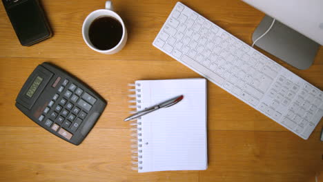 Fountain-pen-falling-onto-notepad-on-office-desk