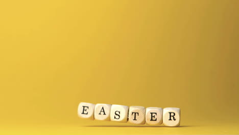 Würfel,-Die-Ostern-Buchstabieren,-Fallen-Vor-Gelbem-Hintergrund