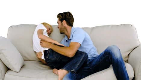 Father-tickling-his-son-on-the-sofa-on-white-background