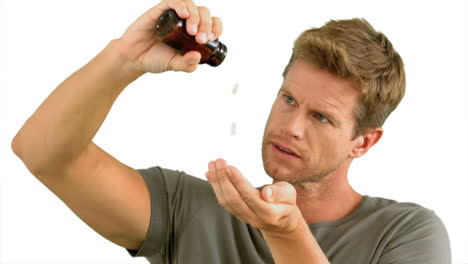 Man-pouring-out-pills-on-white-background