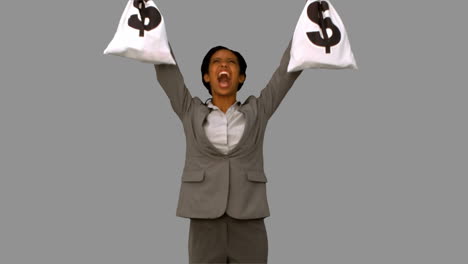 Businesswoman-holding-money-bags-on-grey-screen
