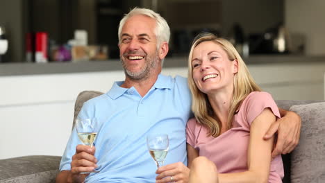 Pareja-Viendo-Televisión-Mientras-Sostiene-Una-Copa-De-Vino-Blanco