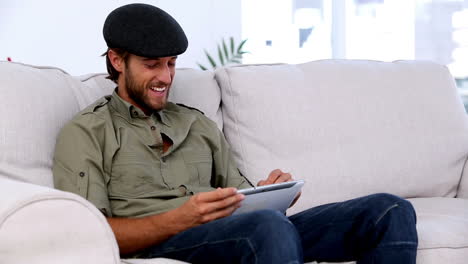 Man-using-tablet-pc-on-the-couch