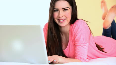 Attractive-woman-using-her-laptop-on-the-bed