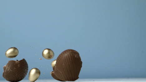 Broken-easter-egg-falling-against-blue-background