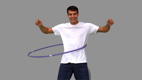 Man-playing-with-a-hula-hoop-on-grey-screen