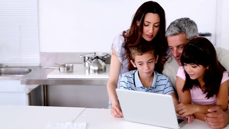 Family-looking-at-laptop-on-the-kitchen