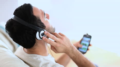 Cheerful-man-listening-to-music-with-his-smartphone