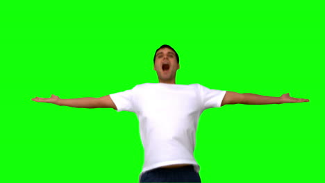 Handsome-man-jumping-and-raising-arms-on-green-screen