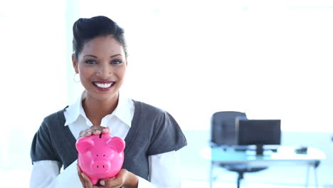 Smiling-businesswoman-checking-piggy-bank