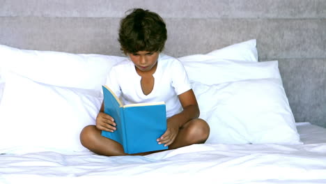 Child-reading-a-book-in-bedroom