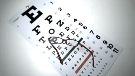 Black-reading-glasses-falling-onto-eye-test-