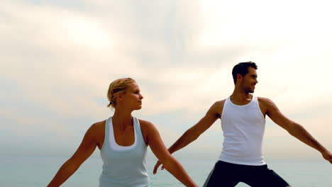 Hombre-Y-Mujer-Haciendo-Yoga-Juntos-En-La-Playa