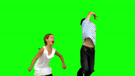 Siblings-jumping-together-on-green-screen