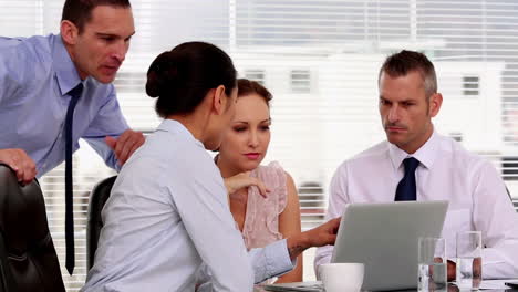 Businesswoman-showing-her-colleagues-something-on-the-laptop-