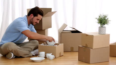 Man-unpacking-tableware