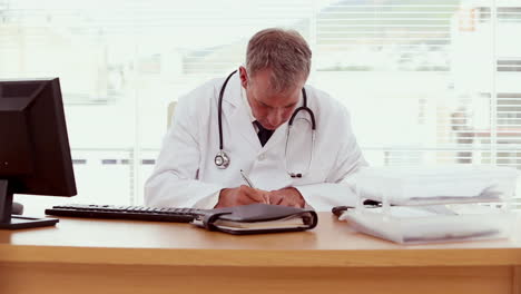 Serious-doctor-writing-