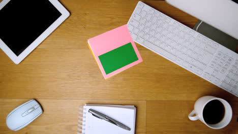 Pink-sticky-notes-with-chroma-key-falling-on-office-desk