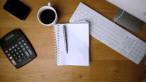 Fountain-pen-and-notepad-falling-onto-office-desk