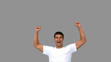 Cheerful-man-raising-arms-on-grey-screen