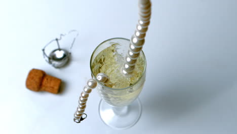 Pearl-necklace-dropping-in-glass-of-champagne