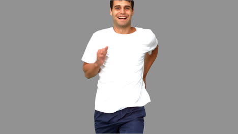 Cheerful-man-jogging-on-grey-screen