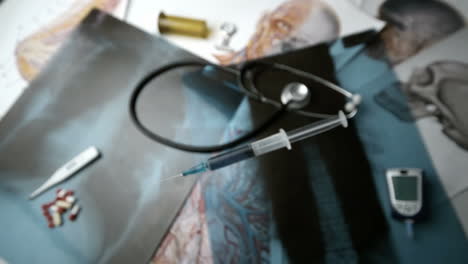 Syringe-with-blue-liquid-falling-over-x-ray-beside-medical-tools