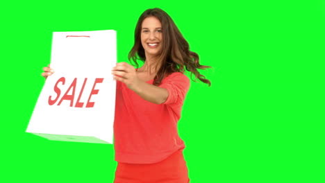 Woman-revolving-while-showing-a-shopping-bag-on-green-screen