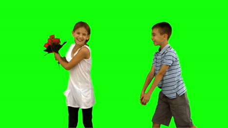 Boy-offering-a-bouquet-of-flowers-to-a-little-girl-on-green-screen