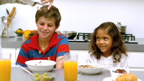 Dad-pouring-cereal-into-his-children-bowls-during-breakfast