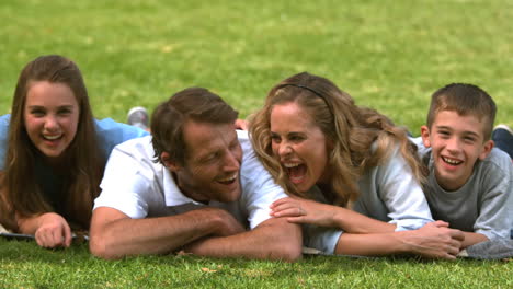 Family-lying-on-the-grass-and-looking-at-camera-