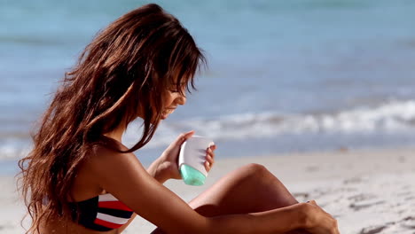 Frau-Trägt-Sonnencreme-Am-Strand-Auf