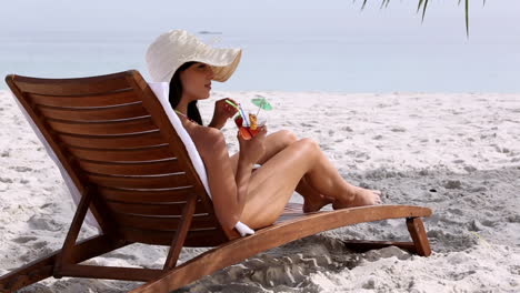 Mujer-Feliz-Bebiendo-Un-Cóctel-En-La-Playa