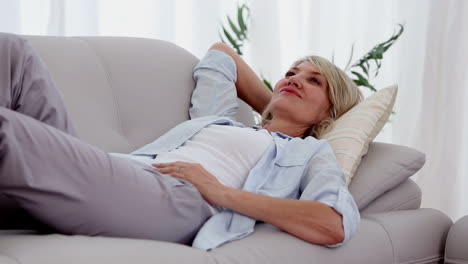 Woman-smiling-and-relaxing-on-sofa