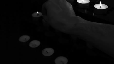 Hand-using-match-to-light-candles-for-worship