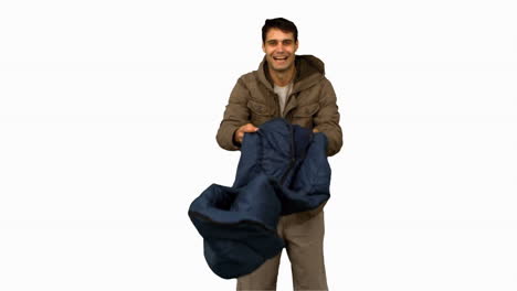 Cheerful-man-rolling-out-his-sleeping-bag-on-white-screen