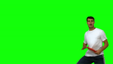 Man-jumping-and-catching-a-frisbee-on-green-screen
