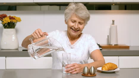 Mujer-Feliz-Vertiendo-Un-Vaso-De-Agua-Para-El-Desayuno