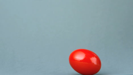 Huevo-Rojo-Girando-Sobre-Fondo-Gris