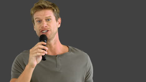 Man-with-microphone-singing-on-grey-screen