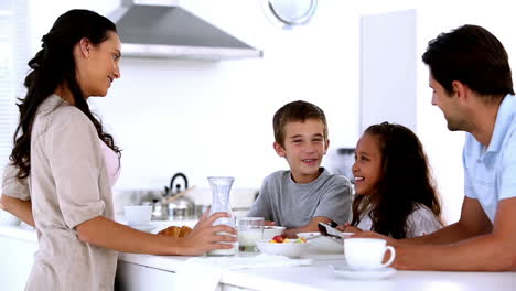 Mutter-Plaudert-Mit-Kindern-Beim-Familienfrühstück-Und-Gießt-Milch-Ein