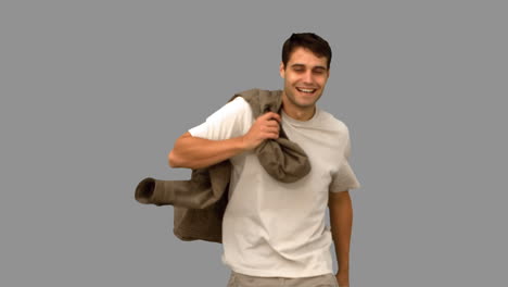 Man-holding-his-coat-on-grey-screen