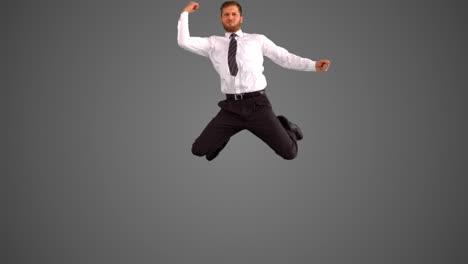 Businessman-jumping-and-punching-air-on-grey-background
