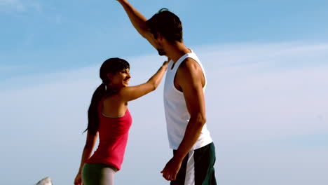 Couple-high-fiving-on-the-beach