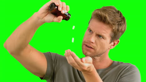 Man-pouring-out-pills-on-green-screen